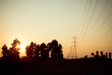High voltage electric pole at sunset,silhouette style.