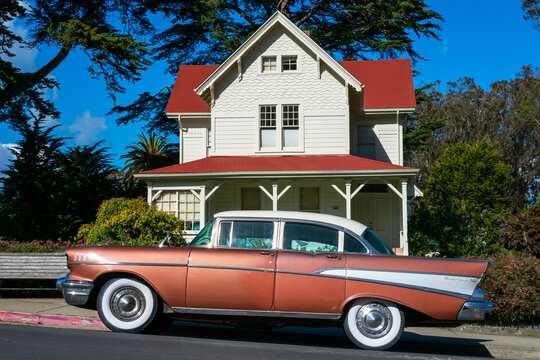 Classic 1957 Chevrolet Bel Air four door sedan parked on on the street in front of eclectic Queen Anne architecture style historic building. - San Francisco, California, USA - 2021
