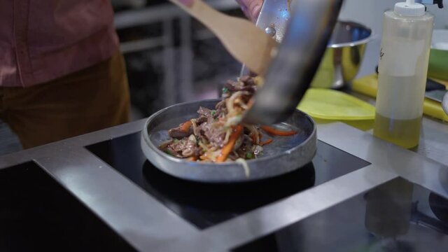 Fajitas cooking, serve meal onto a plate.