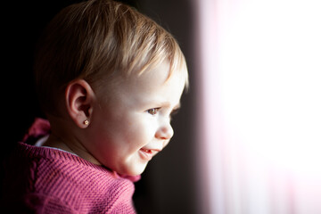 Bebé feliz mirando por la ventana