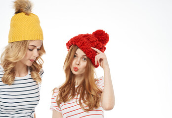 two women in multicolored hats hug friendship communication fashion cropped view