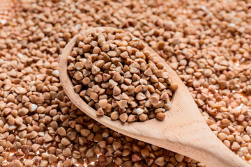Spoon with dry buckwheat, closeup