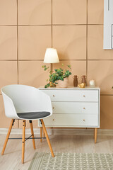 Fototapeta na wymiar Comfortable chair and chest of drawers in interior of modern living room