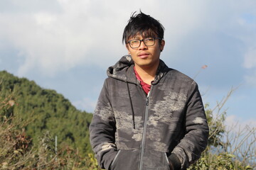 A Nepali boy is wearing thick jacket at putting his hand in pocket