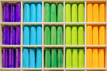 Candles for sale in shelf of interior decorating store. Coloured variety paraffin candles in cozy shop.