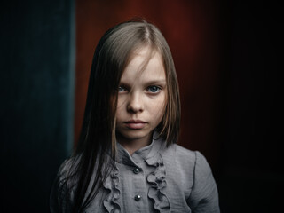Fototapeta premium vintage portrait of a girl in a dress on a dark background beautiful face cropped view