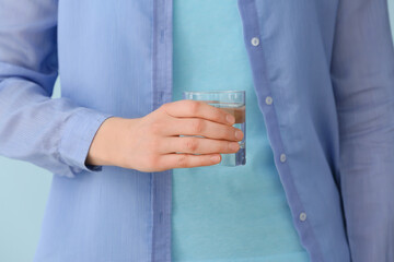 Woman holding glass of water, closeup