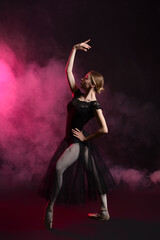 Fototapeta na wymiar Beautiful young ballerina on dark color background