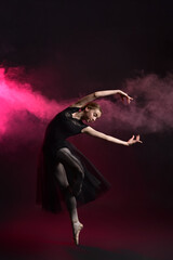 Fototapeta na wymiar Beautiful young ballerina on dark color background
