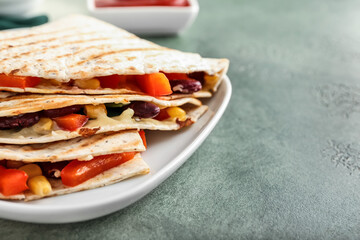 Plate with tasty vegetarian quesadillas on color background, closeup