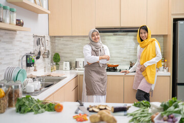 two attractive young muslim woman preparing iftar dinner together. Ramadan and eid mubarak cooking in the kitchen