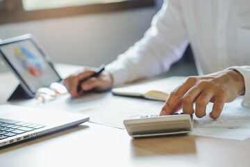 close up hands of accountant calculating tax refund using calculator