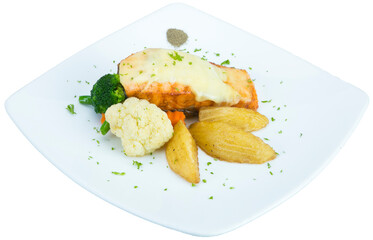 Fried salmon steak with potatoes and vegetables on wooden table