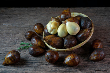 Fresh Waive fruit in Bamboo basket on wooden table, Fresh Salak or Snake Fruit tropical fruit on a wooden table.