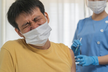 Covid-19, coronavirus asian young man getting vaccine from doctor or nurse giving syringe shot to...