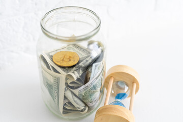 Folding money in a jar on a white wooden background. The background image place for text.