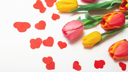 Mothers day. Flowers composition romantic. Colorful flowers tulips with red heart sprinkles on white background. Flat lay, top view, copy space. Valentines concept