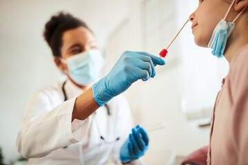 Close-up of small girl having PCR test at doctor's office.