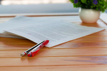 red pen on blurred paperwork in office