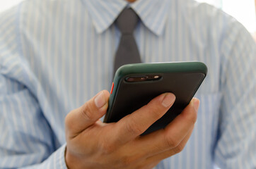 Close up hand holding businessman using mobile smart phone communicate online browse internet.