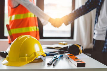 construction worker and contractor. Client shaking hands with team builder in renovation site.
