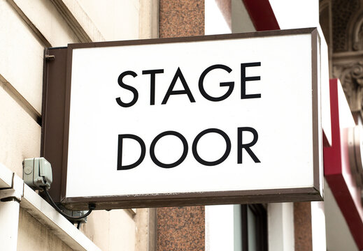 Low angle view of STAGE DOOR sign attached to the exterior wall of theatre in London's West End.