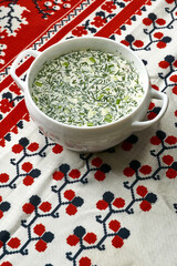 Summer light cold soup with cucumber, radish, egg and dill with the addition of milk whey on the table.