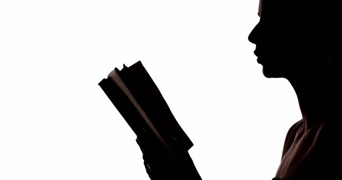 Woman silhouette. Reading poetry. Learning knowledge. Dark contrast profile outline portrait of smart lady with open book isolated on white copy space background.