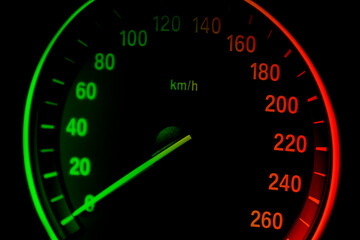 Car instrument panel dashboard closeup with visible speedometer, car interior details in green an red tones