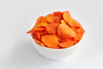 Crispy dried food. Organic tasty chips. Homemade snacks. Sliced carrot. Healthy vegetables. Orange pile