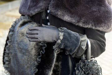 A beautiful girl in a historical retro dress against the background of an old steam locomotive at the station.
