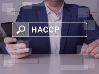 Hazard Analysis and Critical Control Point HACCP phrase on the screen. Modern Banker use cell technologies at office. Concept search and Hazard Analysis and Critical Control Point HACCP 