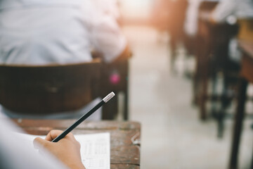 Students doing exam in classroom with stress