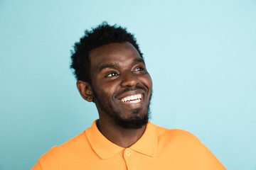 Obraz premium African man's portrait isolated over blue studio background with copyspace