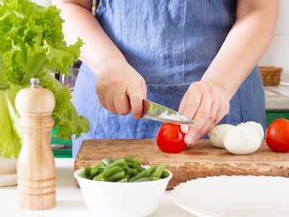 A woman prepares a vegetable salad in the kitchen. Healthy Food. The Concept Of A Diet. Healthy Lifestyle. I Cook At Home. Prepare