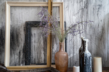 bottles in like candlestick in molten wax, dry flowers on table in creative room