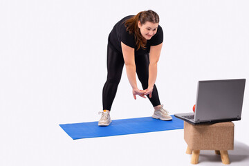 Push yourself. Picture of a young heavy woman bent in sportswear exercising in front of a laptop