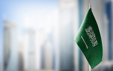 A small flag of Saudi Arabia on the background of a blurred background