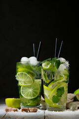 Fresh made Mojito cocktail on dark background. Summer drinks concept.