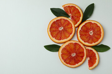 Red orange slices with leaves on white background, space for text