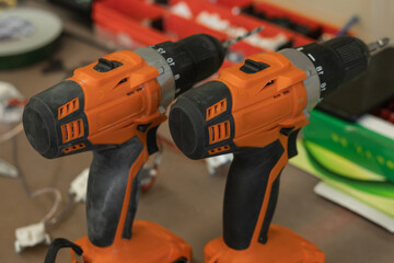 Naklejka premium Orange cordless drill. The screwdriver is used for drilling holes in wood, plastic and metal products, or for working with a screwdriver. Horizontal orientation.