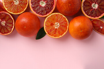 Red oranges and leaf on pink background, space for text