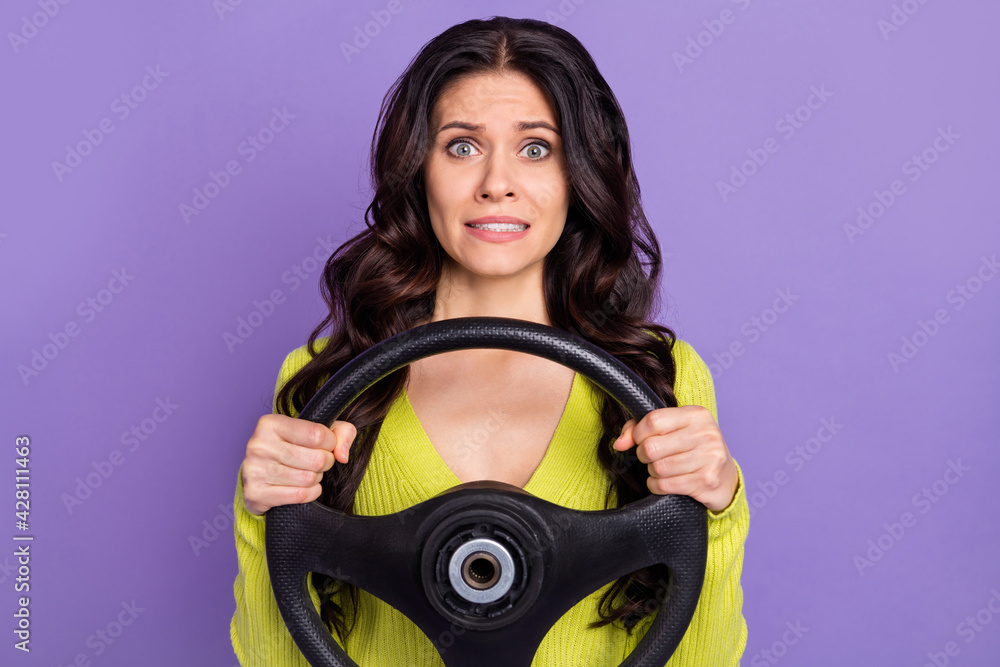 Poster photo of impressed sad brunette curly lady drive wear green sweater isolated on purple background