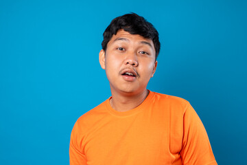 Portrait of Asian man with laugh face. Isolated on blue background.