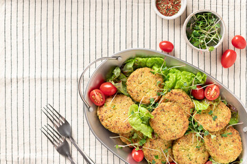 vegan quinoa burgers and salad in metal dish on striped tablecloth. Plant based diet concept. top view, copy space