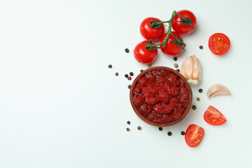Bowl of tomato paste, tomatoes, pepper and garlic on white background
