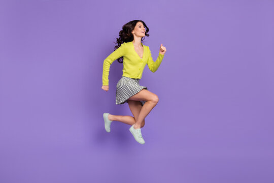 Full length body size side profile photo of pretty girl in plaid skirt jumping running isolated pastel violet color background