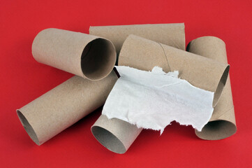 Cartons de rouleaux de papier toilette vides en gros plan sur fond rouge