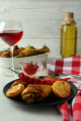 Concept of delicious eating with roast chicken drumsticks on white textured table