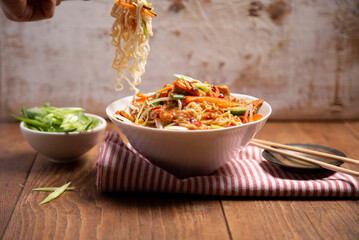 Bowl of stir fried noodles with chopsticks